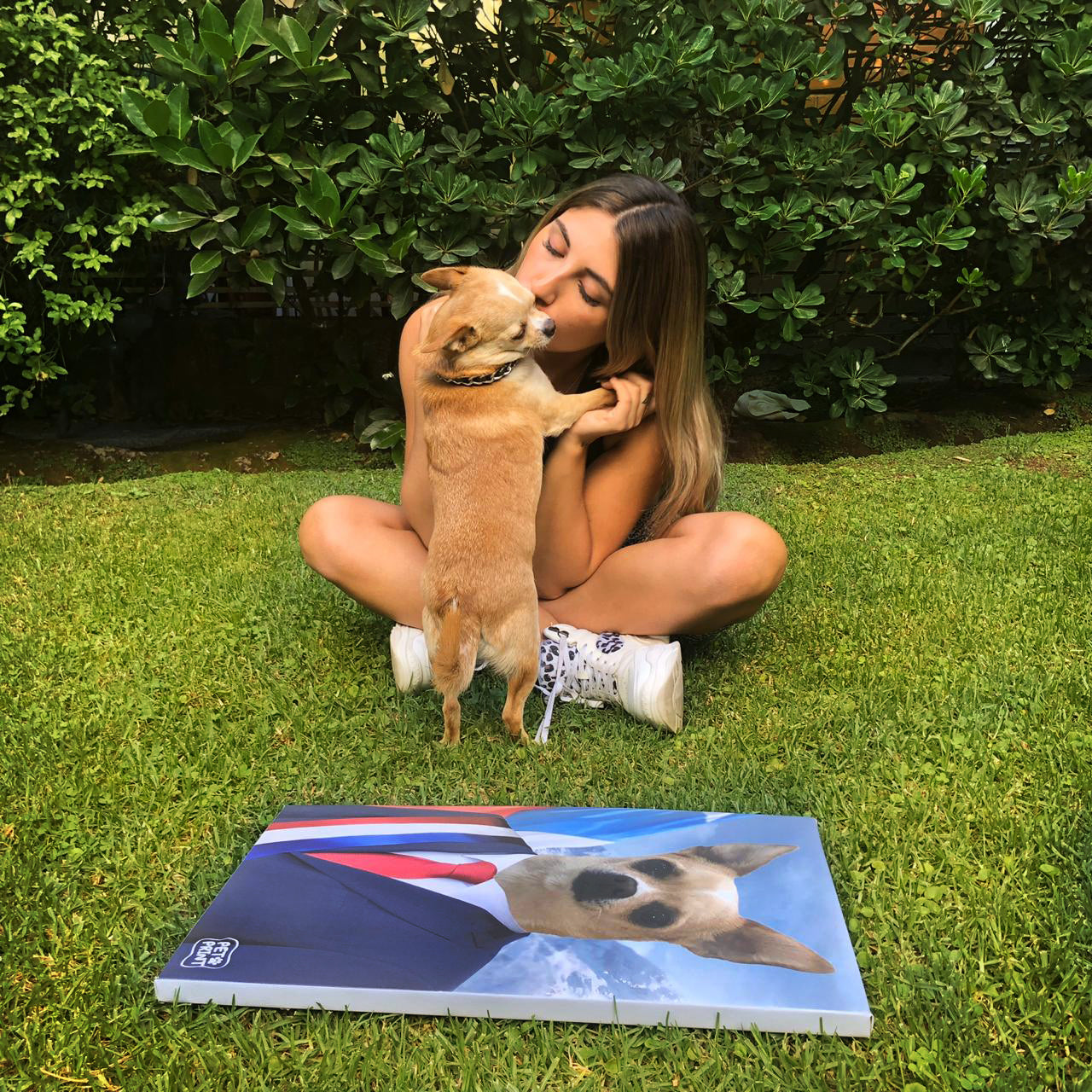 Perrito siendo acariciado por su dueña frente a un cuadro del mismo perrito vestido como presidente